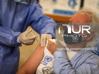 Matthias Schmale, UNRWA's Gaza director, receives a vaccine against the coronavirus disease (COVID-19) at a United Nations-run clinic in Gaz...