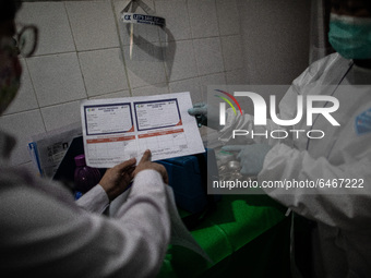 Doctor and nurse checking paper administration covid19 at Public Health Facility Mampang, South Jakarta. Mass vaccination Covid19 for elderl...