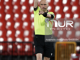 Referee Sergei Karasev shows a yellow card during the UEFA Europa League Round of 32 match between Granada CF and SSC Napoli at Estadio Nuev...