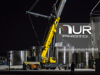 Engineers work into the night dismantling SN-5 and building Super Heavy Booster behind the low bay at SpaceX's south Texas campus on the eve...
