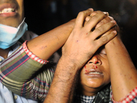A protestor tries to stop her bleeding as she was hit by police during a torchlight procession over the death of a Bangladeshi writer Mushta...