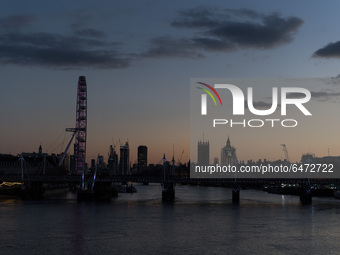 LONDON, UNITED KINGDOM - FEBRUARY 26, 2021: A view of the London Eye, River Thames and Houses of Parliament during sunset after a warm and c...
