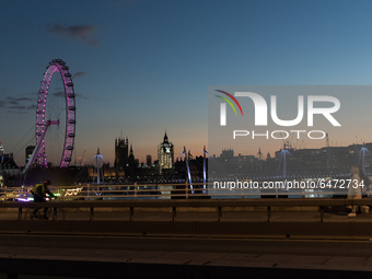 LONDON, UNITED KINGDOM - FEBRUARY 26, 2021: A view of the London Eye, River Thames and Houses of Parliament from Waterloo Bridge during suns...