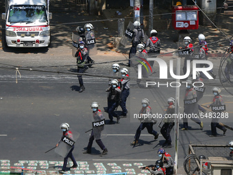 Riot police fire tear gas and rubber bullets towards protesters during a demonstration against the military coup in Yangon, Myanmar on March...