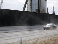 A Tesla is seen rushing down the dusty road to the launch pad at the SpaceX South Texas campus in Boca Chica, Texas on March 8, 2021.   (