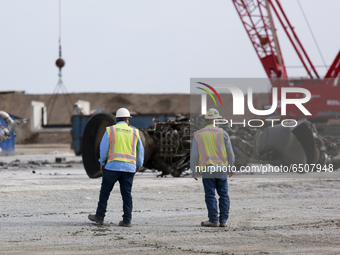 Engineers survey the destroyed Raptor engine from Starship SN-10’s wreckage near the launch pad at SpaceX’s South Texas campus in Boca Chica...