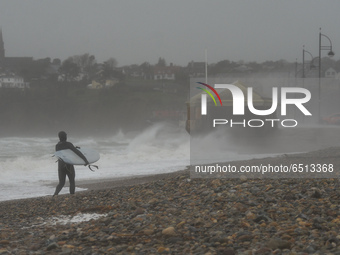 A surfer on the beach at Tramore in County Waterford on the South East coast of Ireland, where the yellow 100 km/h weather warning is in eff...