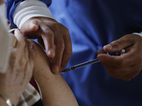 A person receives a dose of Pfizer-BioNTech Covid-19 vaccine before inject to an elderly, during mass vaccine inside of Hermanos Lopez Rayon...