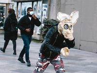 a man dressed as a Eastern Bunny walks in the mid of strong wind in front of Dom Cathedral in Cologne, Germany on March 11, 2021 as Storm Kl...
