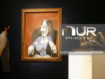 A member of staff poses with oil on canvas work 'Femme assise dans un fauteuil noir (Jacqueline)', by Pablo Picasso, estimated at GBP6,000,0...
