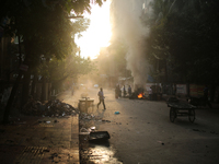 A pedestrian on move as construction workers working on a road that creates toxic smoke in Dhaka, Bangladesh on March 17, 2021. Air pollutio...