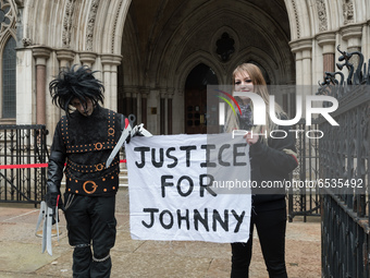 LONDON, UNITED KINGDOM - MARCH 18, 2021: Johnny Depp's supporters, one dressed as the movie character Edward Scissorhands (L), hold a banner...
