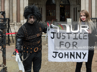 LONDON, UNITED KINGDOM - MARCH 18, 2021: Johnny Depp's supporters, one dressed as the movie character Edward Scissorhands (L), hold a banner...