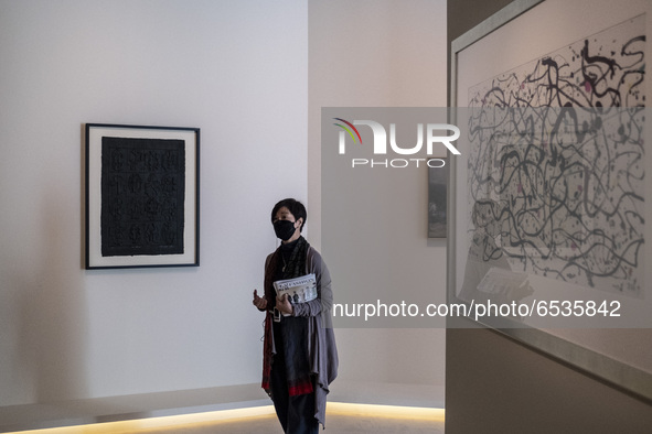 A Worker explains artwork inside the ‘Not a Fashion Store’ art exibition in Hong Kong, Thursday, March 18, 2021. 
