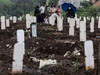 Families member of Covid19 Death Victim visiting the grave at Srengseng Sawah, Jakarta, Indonesia on March 19, 2021. Number of covid19 death...