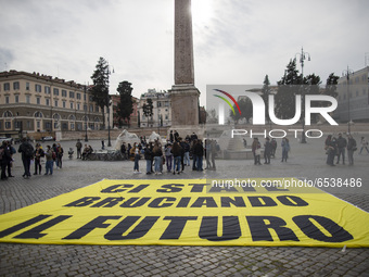A huge banner with a sign reading 'You are burning our future' is put on the ground during  a Fridays For Future  demonstration in Piazza de...