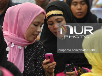 MANILA, Philippines - Muslim women check their mobile phones as Filipino Muslims take part in a rally as they celebrate in Mendiola bridge i...