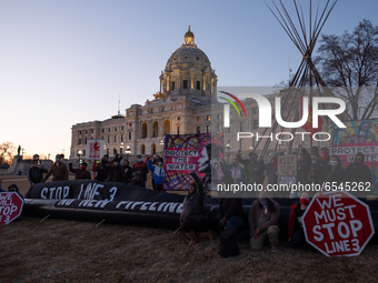 Indigenous activists and water protestors pose with an art installation outside of the Minnesota State Capitol building in protest against G...