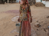 With less rainfall and water at scarce in the arid region of Thar desert, an Indian woman with water collected from a harvested water tank a...