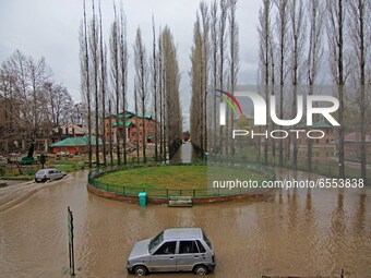 A car (L) moves through the water-logged entrance of historic Amar Singh College in Srinagar,Kashmir on March 24, 2021.The incessant rain ac...