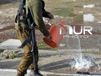 An Indian policeman cleaning the blood near the spot where suspected militants carried an attack on Indian paramilitary forces in Lawaypora...