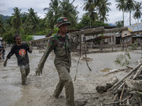 Soldiers and volunteers clean up the remaining mud that hit a house in Beka Village, Marawola District, Sigi Regency, Central Sulawesi Provi...