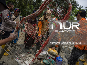 Volunteers together with the police evacuate residents 'belongings from a pool of mud that hit residents' houses in Beka Village, Marawola D...