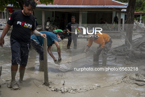 Residents and volunteers cleaned up the remaining mud that hit houses in Beka Village, Marawola District, Sigi Regency, Central Sulawesi Pro...