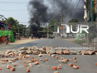 Smoke rises as protesters block roads with burning tyres during a demonstration against the military coup in Thanlyin township, outskirts of...