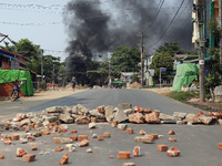 Smoke rises as protesters block roads with burning tyres during a demonstration against the military coup in Thanlyin township, outskirts of...