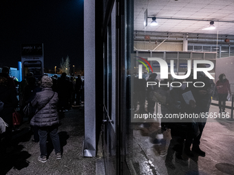 In the picture People queuing in the night outside the Padua exhibition center awaiting vaccination. They all wear protective masks but cann...