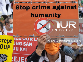 Man holding a sign reading ''Stop Crime against humanity''during a prayer's Anti Myanmar Coup protest in Taipei, Taiwan, on March 28, 2021....