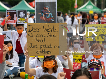 Young Boy besides a Baner reading ''Dear World We don't need Nobel Price, just protect our children''during a prayer's Anti Myanmar Coup pro...
