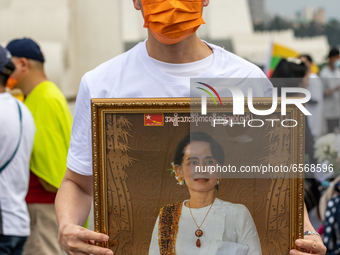 Man holding a portrait of Myanmar official Leader Aung San Suu Kyi during a prayer's Anti Myanmar Coup protest in Taipei, Taiwan, on March 2...
