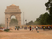 People rush to find cover at India Gate lawns during a dust storm, at Rajpath on March 30, 2021 in New Delhi, India. The India Meteorologica...