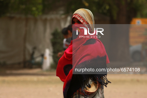 A woman uses a shawl to cover herself during a dust storm, at India Gate on March 30, 2021 in New Delhi, India. The India Meteorological Dep...
