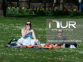 LONDON, UNITED KINGDOM - MARCH 30, 2021: People relax during exceptionally warm and sunny weather in St James's Park, making the most of eas...