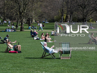 LONDON, UNITED KINGDOM - MARCH 30, 2021: People enjoy exceptionally warm and sunny weather in St James's Park, making the most of eased Coro...