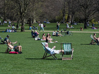 LONDON, UNITED KINGDOM - MARCH 30, 2021: People enjoy exceptionally warm and sunny weather in St James's Park, making the most of eased Coro...