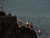 Swimmers line up before jumping into the water at Forty Foot in Sandycove, Dublin, in fine sunny weather during level 5 COVID-19 lockdown....