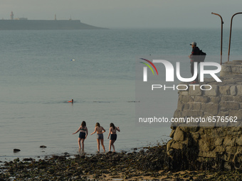 Young girls walk into the sea at Sandycove beach, Dublin, in fine sunny weather during level 5 COVID-19 lockdown. 
On Tuesday, March 30, 202...