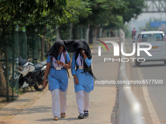 School students covers their head and face in their cloths as to protect them from the heat wave as they returns back home in the afternoon...