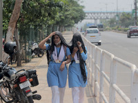 School students covers their head and face in their cloths as to protect them from the heat wave as they returns back home in the afternoon...