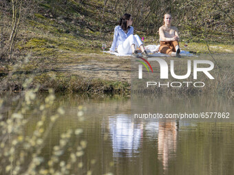 Young girls enjoy the sun while having a pic nic. Sunny weather days with high temperatures, around 25 degrees centigrade during the spring...