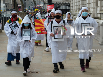 LONDON, UNITED KINGDOM - MARCH 31, 2021: Demonstrators wearing traditinal white Chinese funeral attire march through central London to the C...