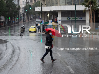 People seen wearing protected mask and holding umbrellas during a rainy day in Athens, Greece on April 1, 2021.  (