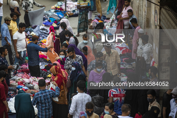 Residents gather to buy their needs at New Market amid the COVID-19 coronavirus emergency in Dhaka, Bangladesh on April 2, 2021. 