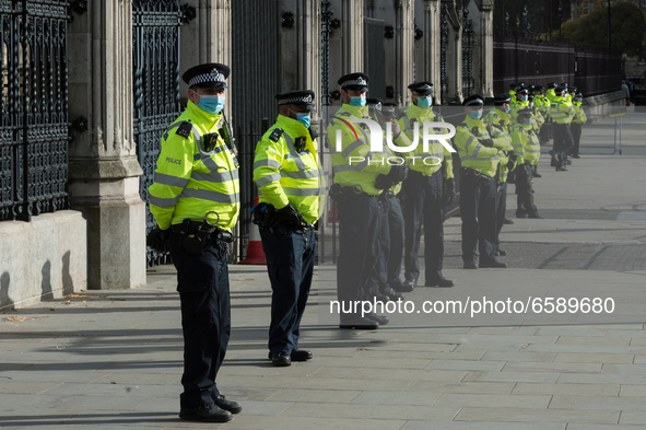 LONDON, UNITED KINGDOM - APRIL 03, 2021: Police officers stand in front of the gates of the Houses of Parliament in central London after a p...