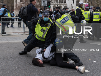LONDON, UNITED KINGDOM - APRIL 03, 2021: Police officers arrest a female demonstrator in Parliament Square after a protest against governmen...