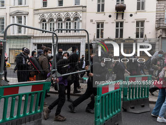 LONDON, UNITED KINGDOM - APRIL 03, 2021: Protesters pull down a fence around roadworks in central London after a protest against government’...